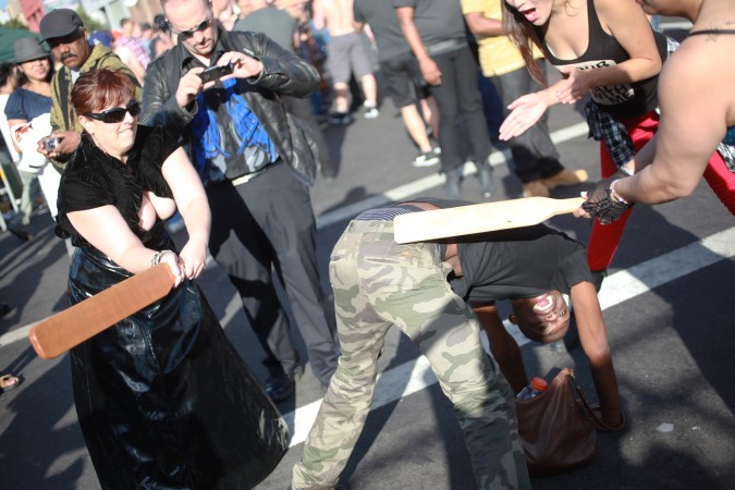 Two woman paddle a man at the San Francisco Folsom Street Fair, September 23, 2012. 